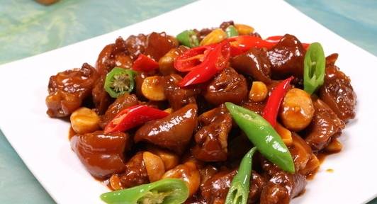 3,锅中下油烧热,放入蒜头爆香,倒入猪尾巴翻炒3分钟.