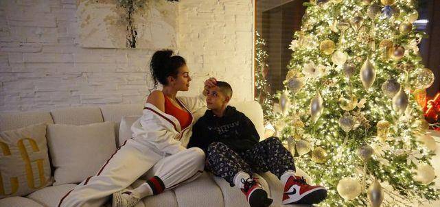 玲珑 C罗女友跟11岁迷你罗玩雪，穿红连体裤身姿玲珑，拿香奈儿包遮肚