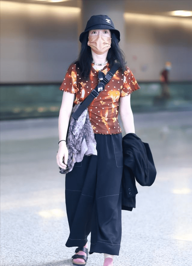 个性 周迅走机场挺“张扬”，穿棕色星空小半袖，脚上穿的粉袜子更抢镜