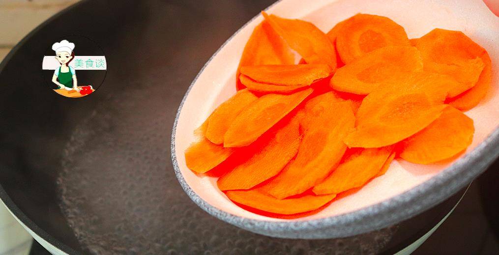 3,锅里加水烧开,水开之后加入胡萝卜片下锅焯水,烫20秒胡萝卜稍微变软