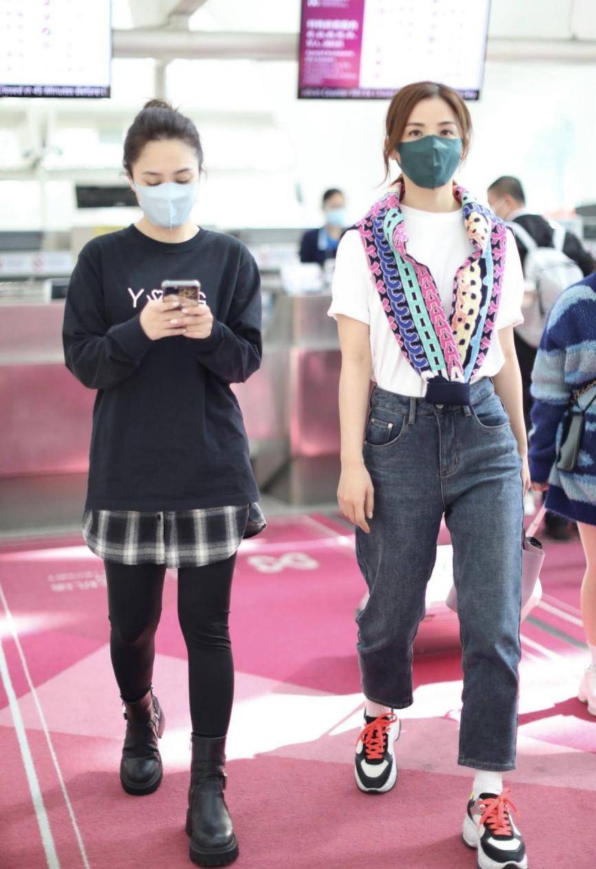 卫衣 Twins合体走机场，一个穿短袖一个穿两件长衫+皮靴，仿佛两个季节