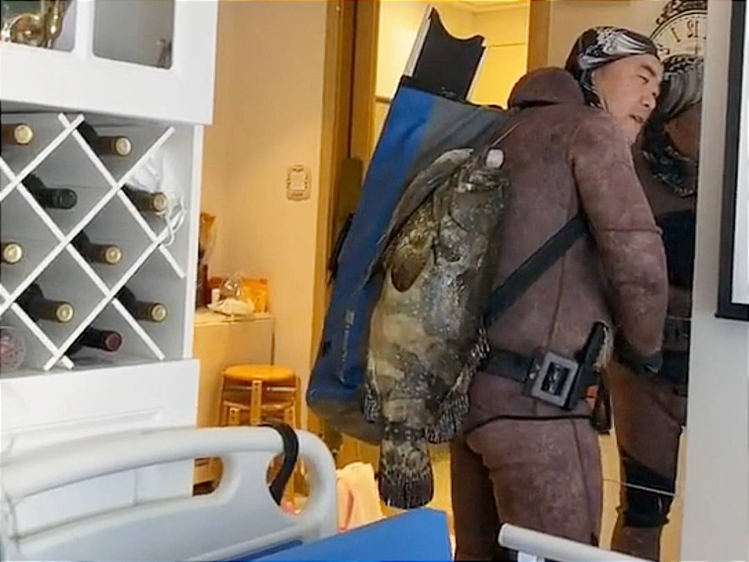 有目击者称,这名男子抓到鱼回到小区之后,背着