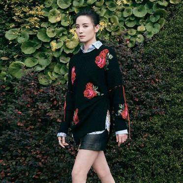 好身材 身穿一件印花设计的黑色针织衫叠穿浅色条纹衬衫,很有层次感,再搭配皮质短裙