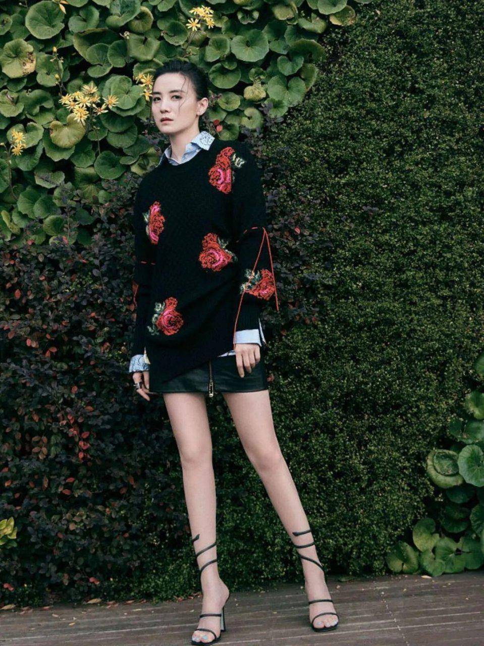 好身材 身穿一件印花设计的黑色针织衫叠穿浅色条纹衬衫,很有层次感,再搭配皮质短裙