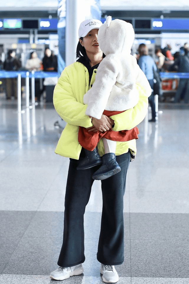 整体 朱丹罕见抱女儿走机场！白帽黄衣超扮嫩成功，哪像四十岁的女人