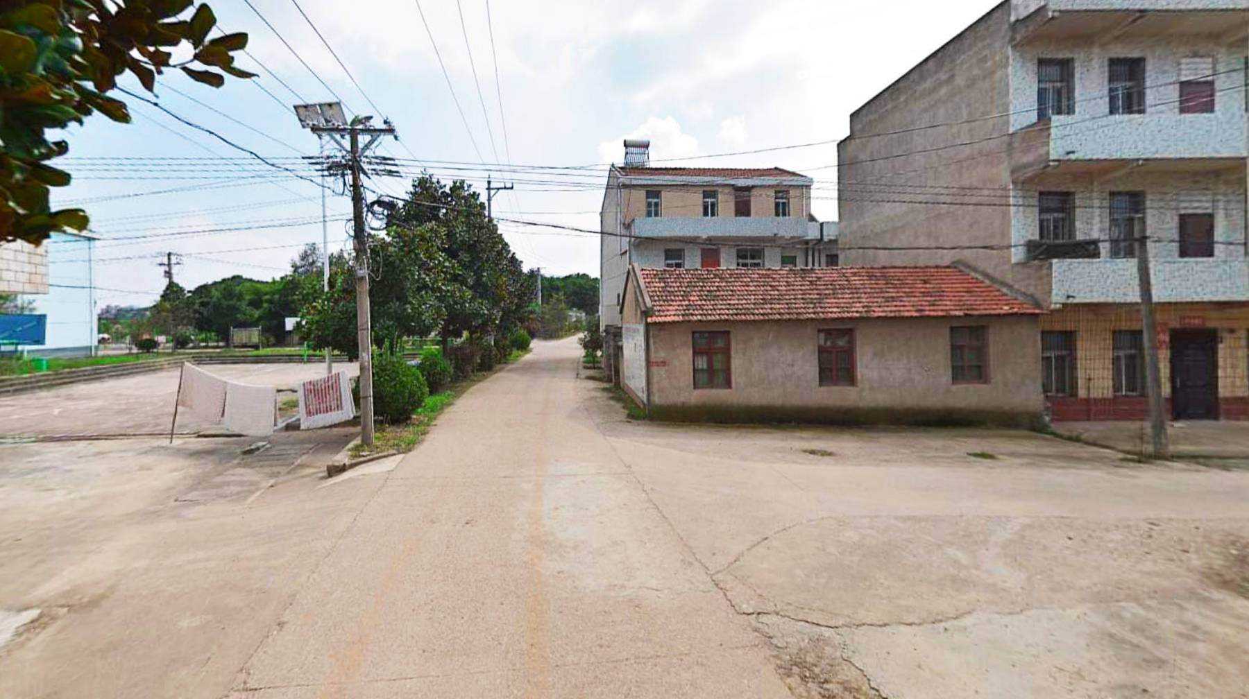 村子的入口处只有一条主路,一栋老房子堆在一边,非常刺眼.