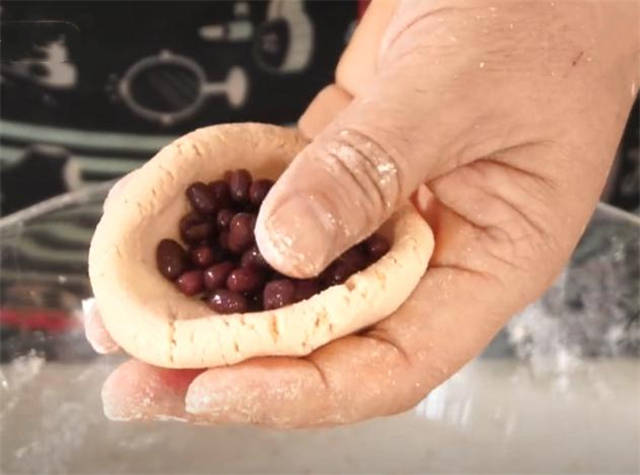 5.这个面不用醒,揪小块面团揉圆按压成面胚,包上红豆馅收口捏紧.6.