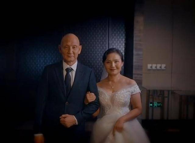 63岁的杜玉明换掉了西服,老婆张艳茹也穿上了婚纱礼服,郎才女貌.