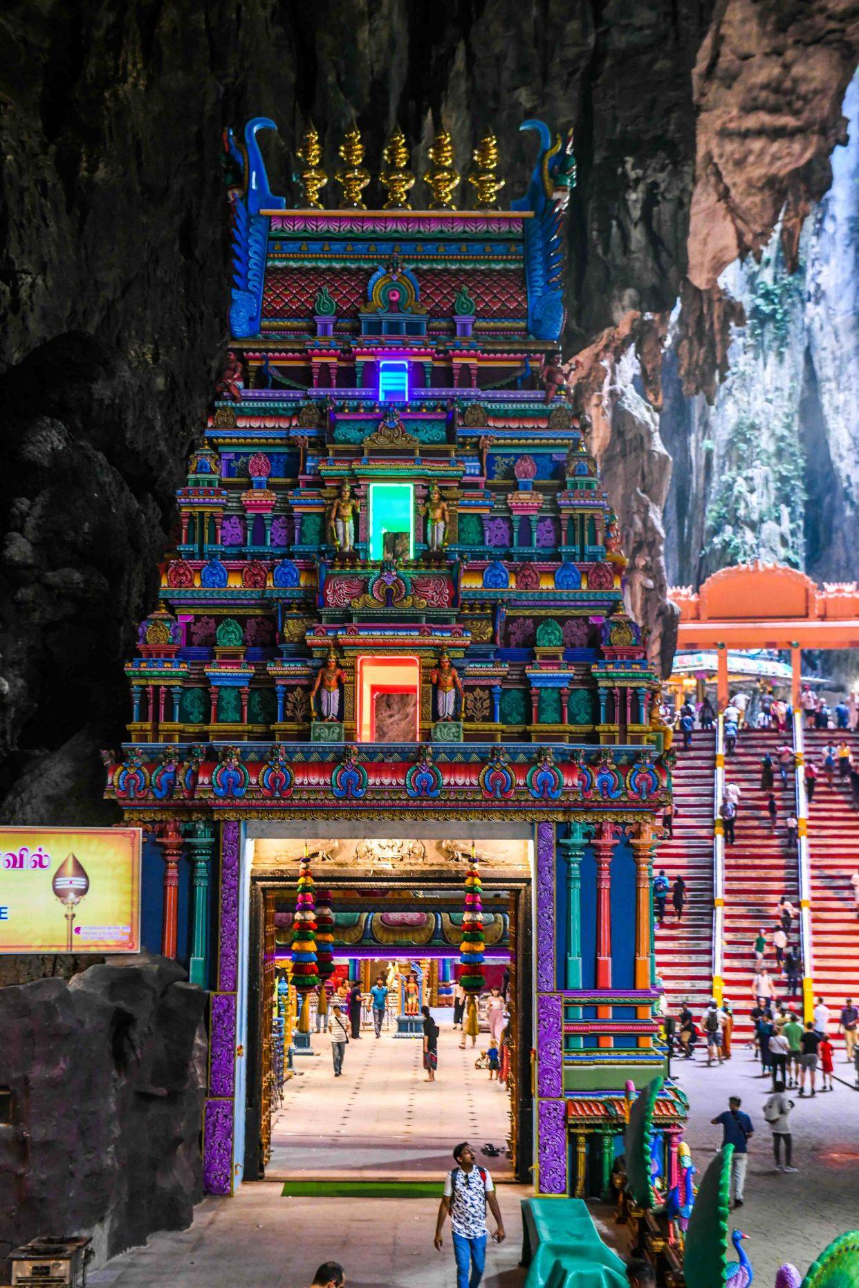 山洞前高大威武的金色神像——这尊神像是湿婆和雪山女神的儿子室建陀