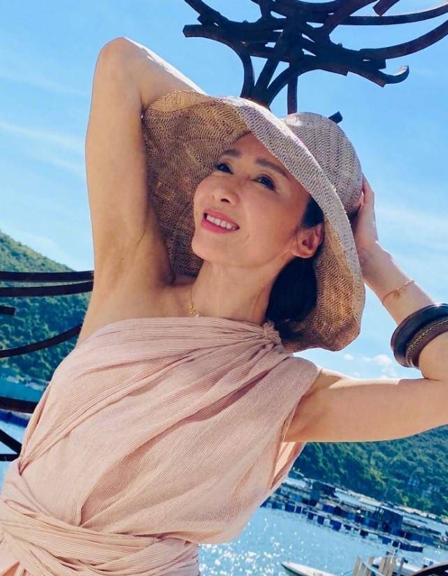 原创49岁黎姿高温下拍美照一袭长裙小秀香肩海边享受阳光浴