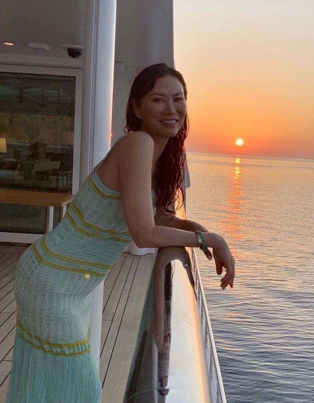 50岁邓文迪不显老,穿吊带裙携友海边游,比17岁女儿包臀裙还大胆_grace