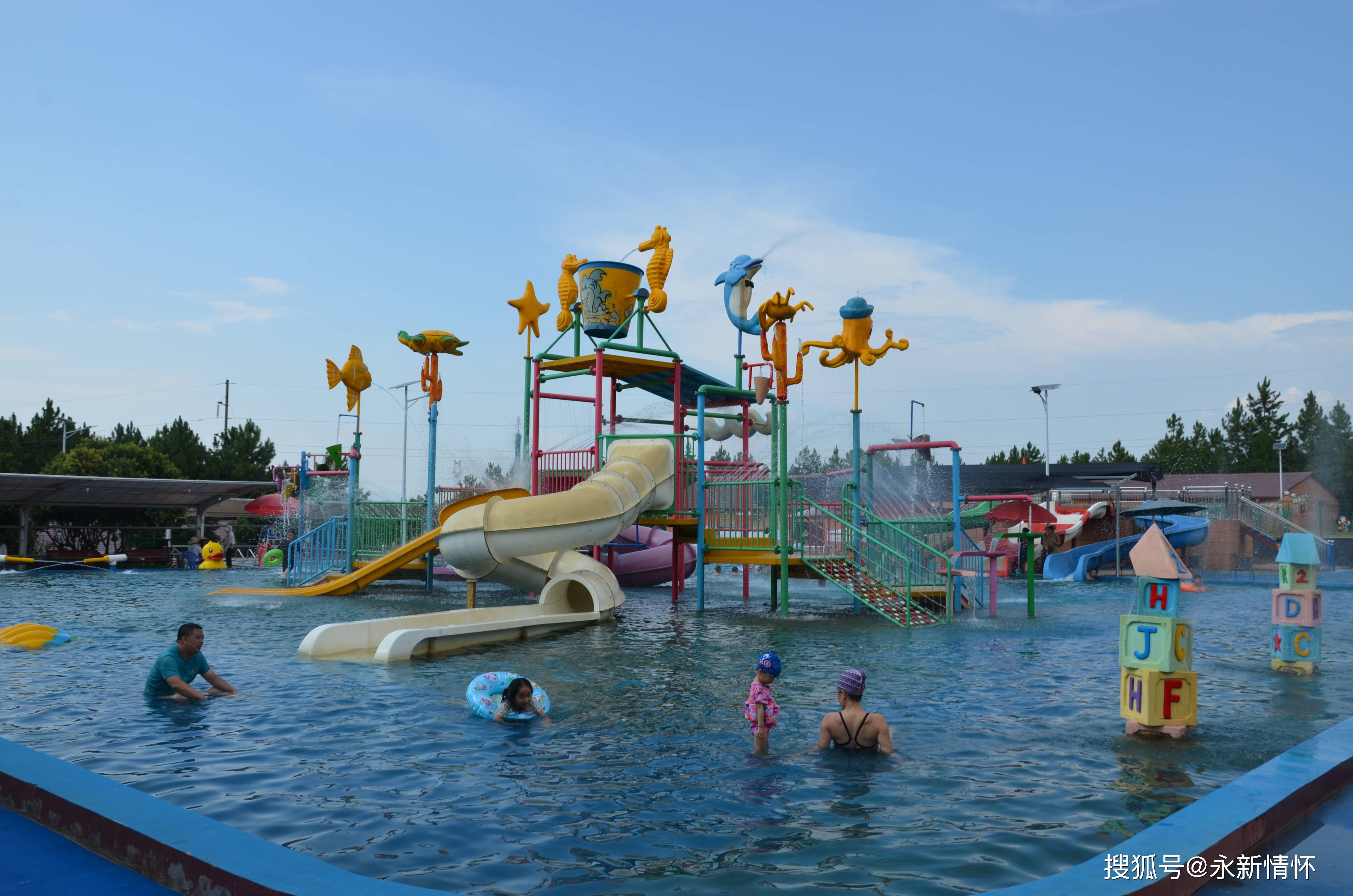 7月31日,在永新县中蝶泉水塘儿童水上乐园, 市民们带着孩子在水里嬉戏