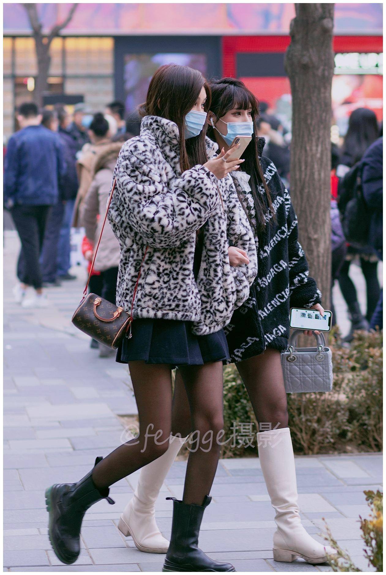 街拍:两个美女好闺蜜同穿小裙子皮靴黑丝袜,谁更时尚谁更美?
