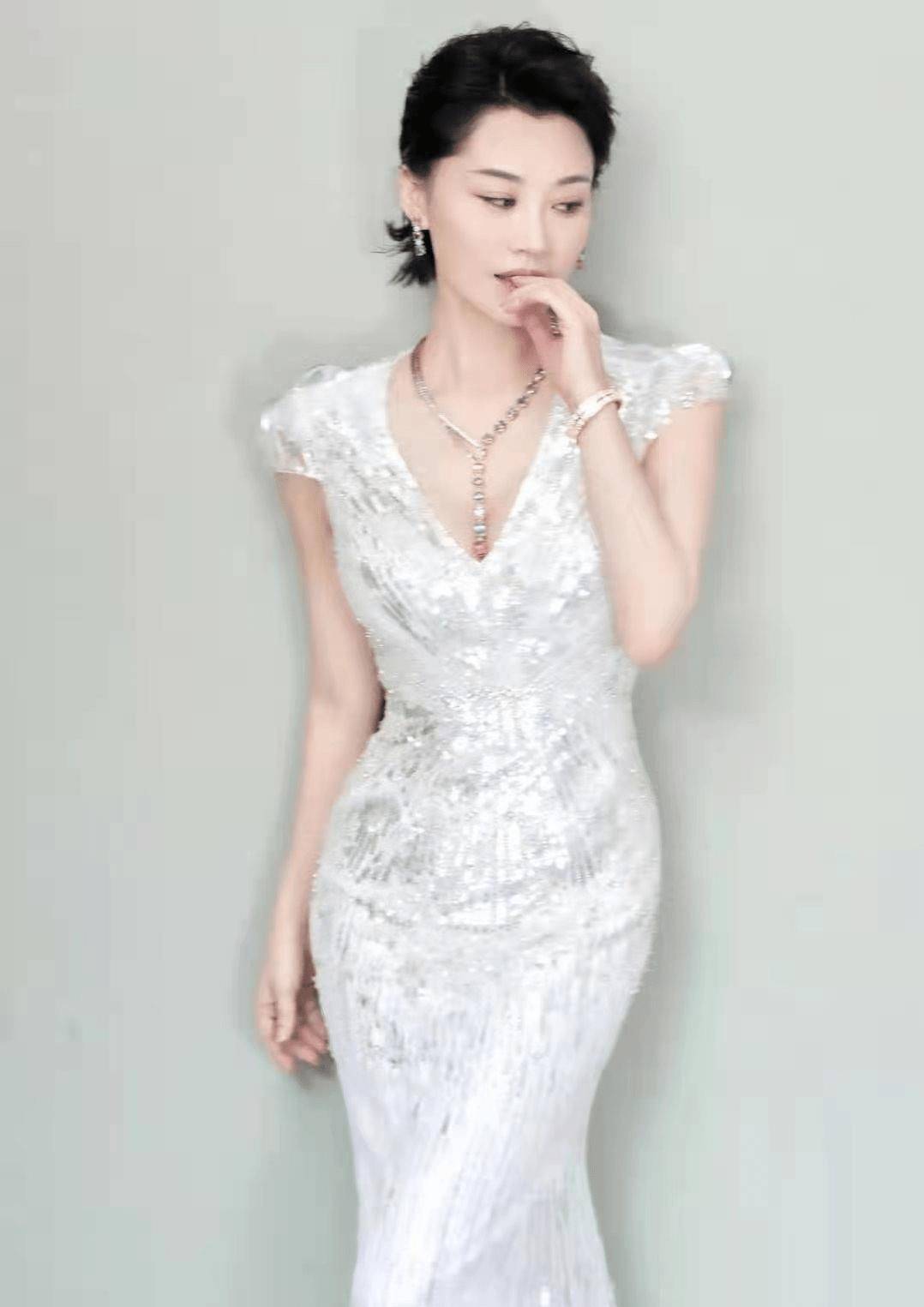 许晴身穿一件高贵典雅的连衣裙,上面还点缀着一些亮片,在灯光的照耀下