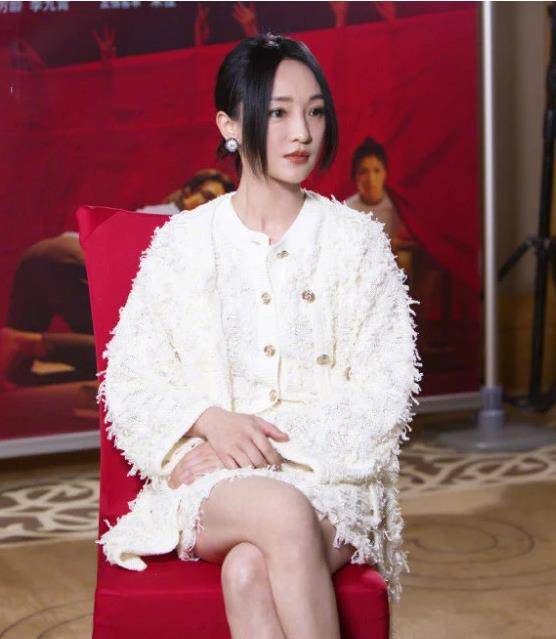 照片中,周迅的眼睛弯弯的,笑容灿烂,抬头向前看,穿着带大腿根的蓝紫色