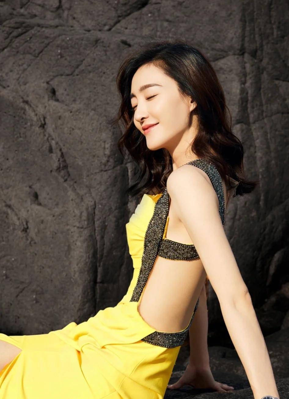 王丽坤坐在礁石上拍美照,一身露背长裙大背美背,火辣身材好吸睛