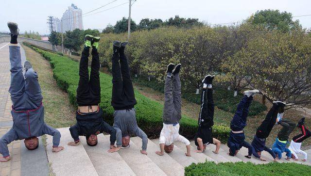 冬季来临,大爷们也在晨练时玩起了新花样,倒立,一字马,一指禅