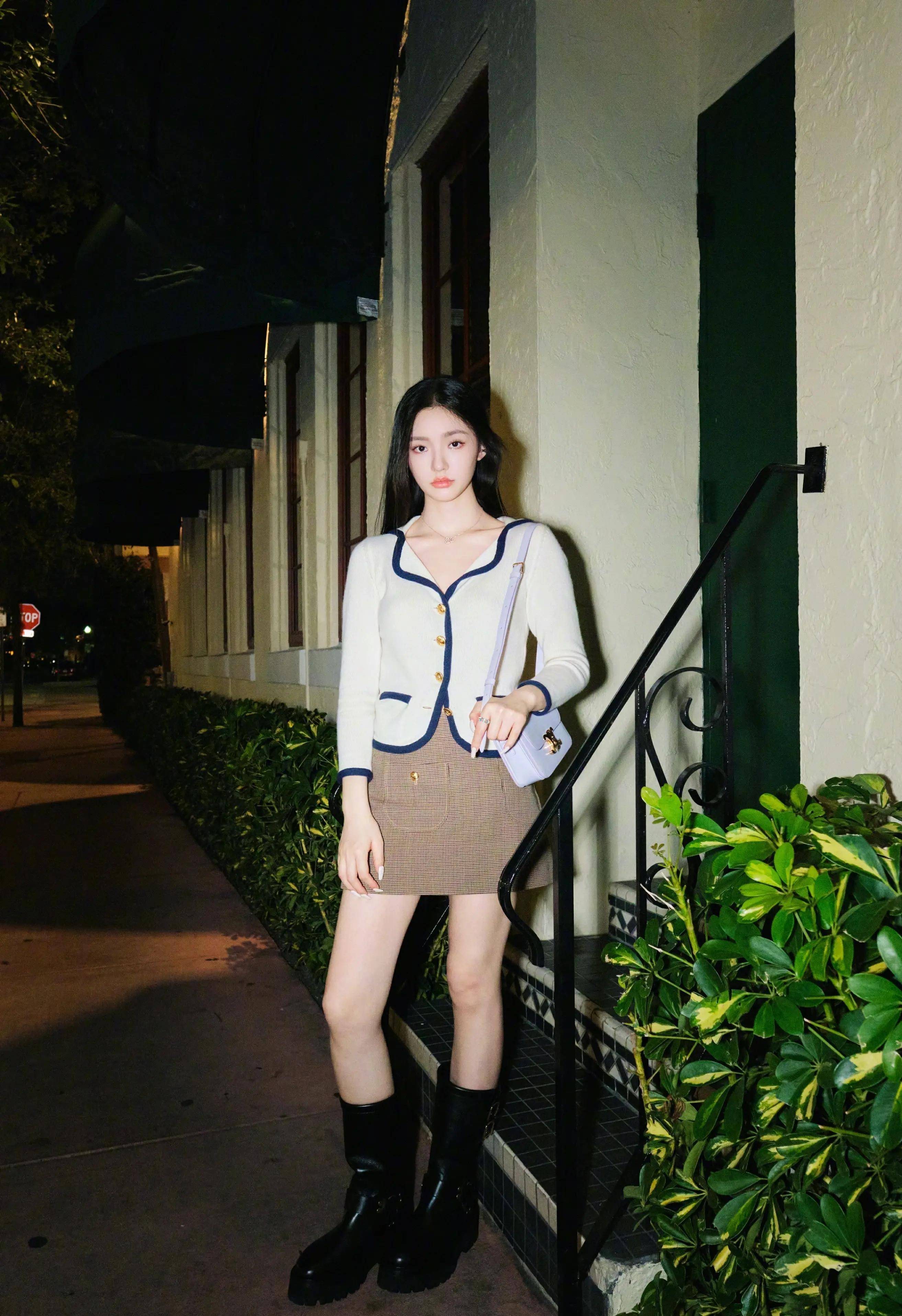 漫步在夜色中,林允的白色毛衣和棕色超短裙秀出了她的美腿,时尚女神范