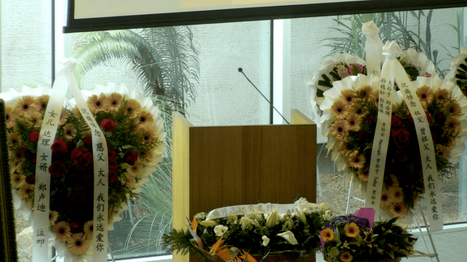 达奇女儿达理,女婿郑卢迪的花圈摆在中间,挽联上写着:"沉痛悼念慈父