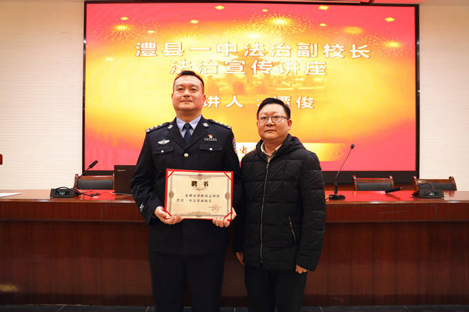 澧县一中党委书记,校长曾斌(右)为谭俊(左)颁发澧县一中法治副校长