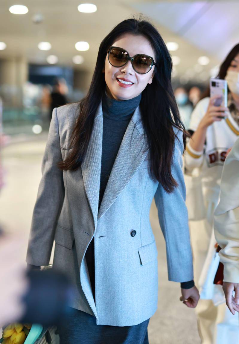 刘涛身穿灰色西装,戴着墨镜,显得成熟优雅,手里捧着鲜花,微笑着_演艺