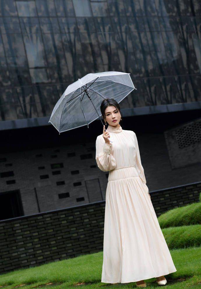 刘涛身穿白色长裙,优雅地撑着雨伞,盘发而行,尽显知性魅力_照片_宁静