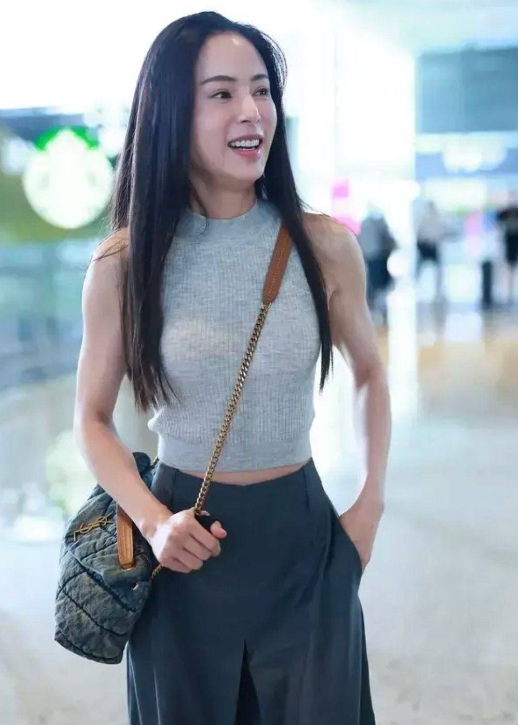 57岁的李若彤意外现身机场,他穿着紧身衣服,戴着长帽子,背影像小姑娘