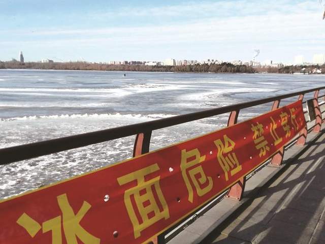 湖边警示标语 本组图片 城市晚报全媒体记者 刘佳雪 摄游客穿行南湖