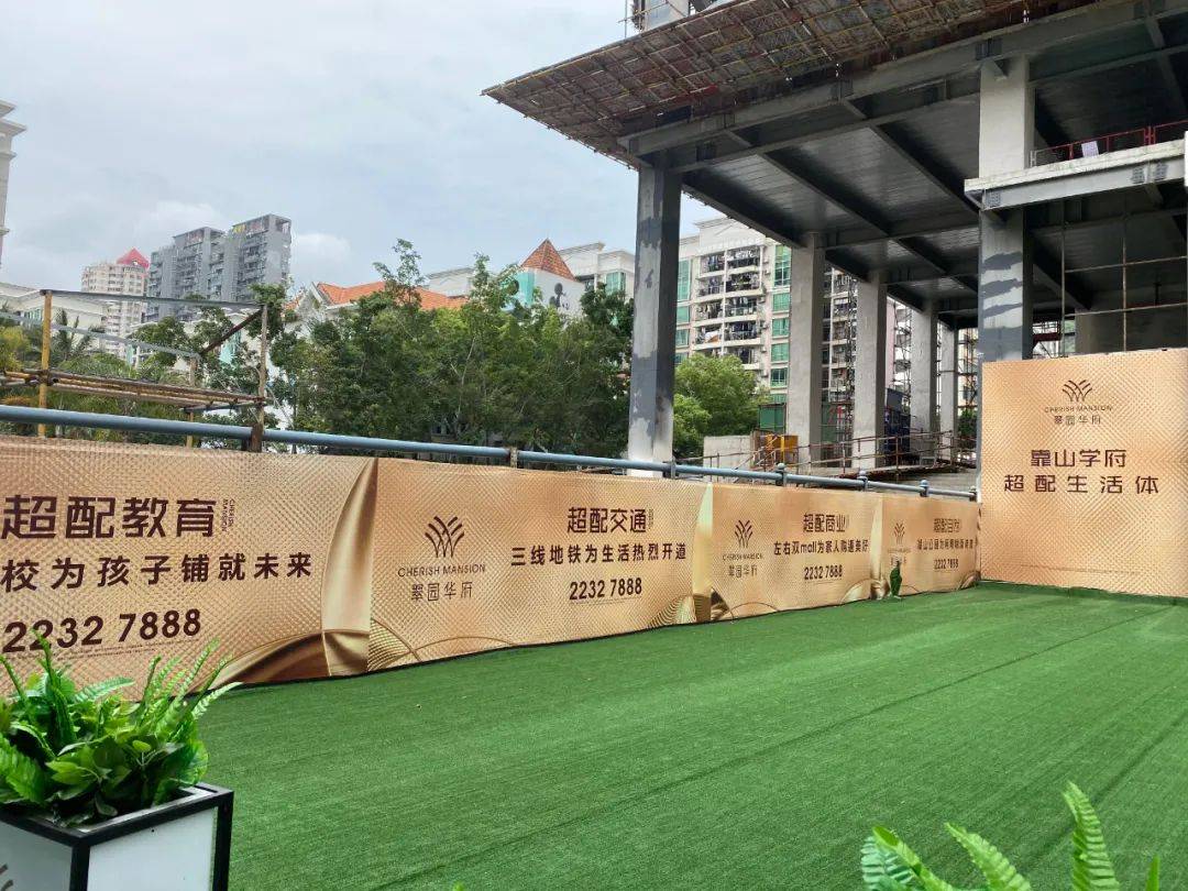 路边的围挡是项目的卖点宣传文案和咨询电话.