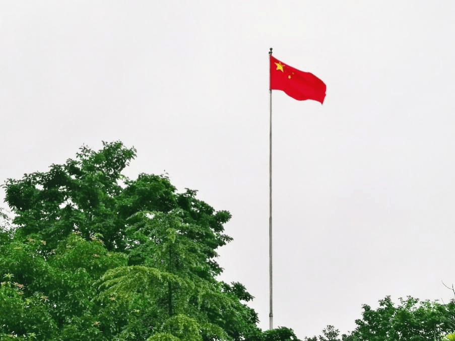 反而将春意盎然洗刷得更加亮眼,红旗迎着风在天空中起舞,如同跳跃的