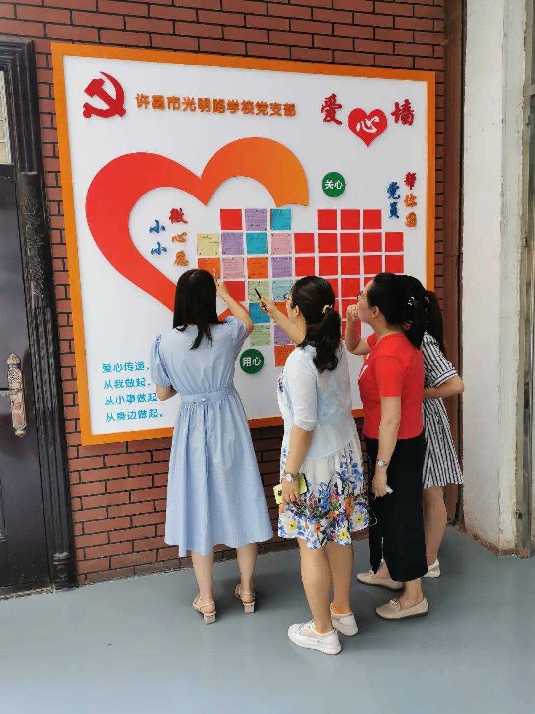 党员教师们积极行动起来,在心愿墙认领微心愿