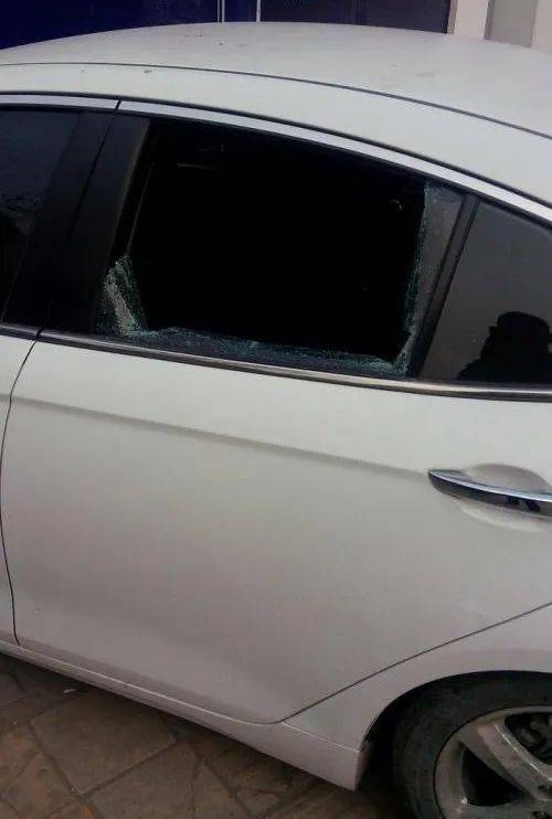 在沧州市运河区锦绣天地小区人行道停车位处的白色奔驰汽车车玻璃被砸