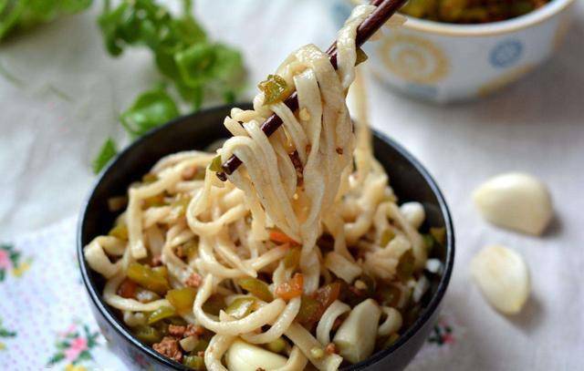 女人把水大火烧开,面条细细的切了,洒在滚开的水花上,滴溜溜的几个