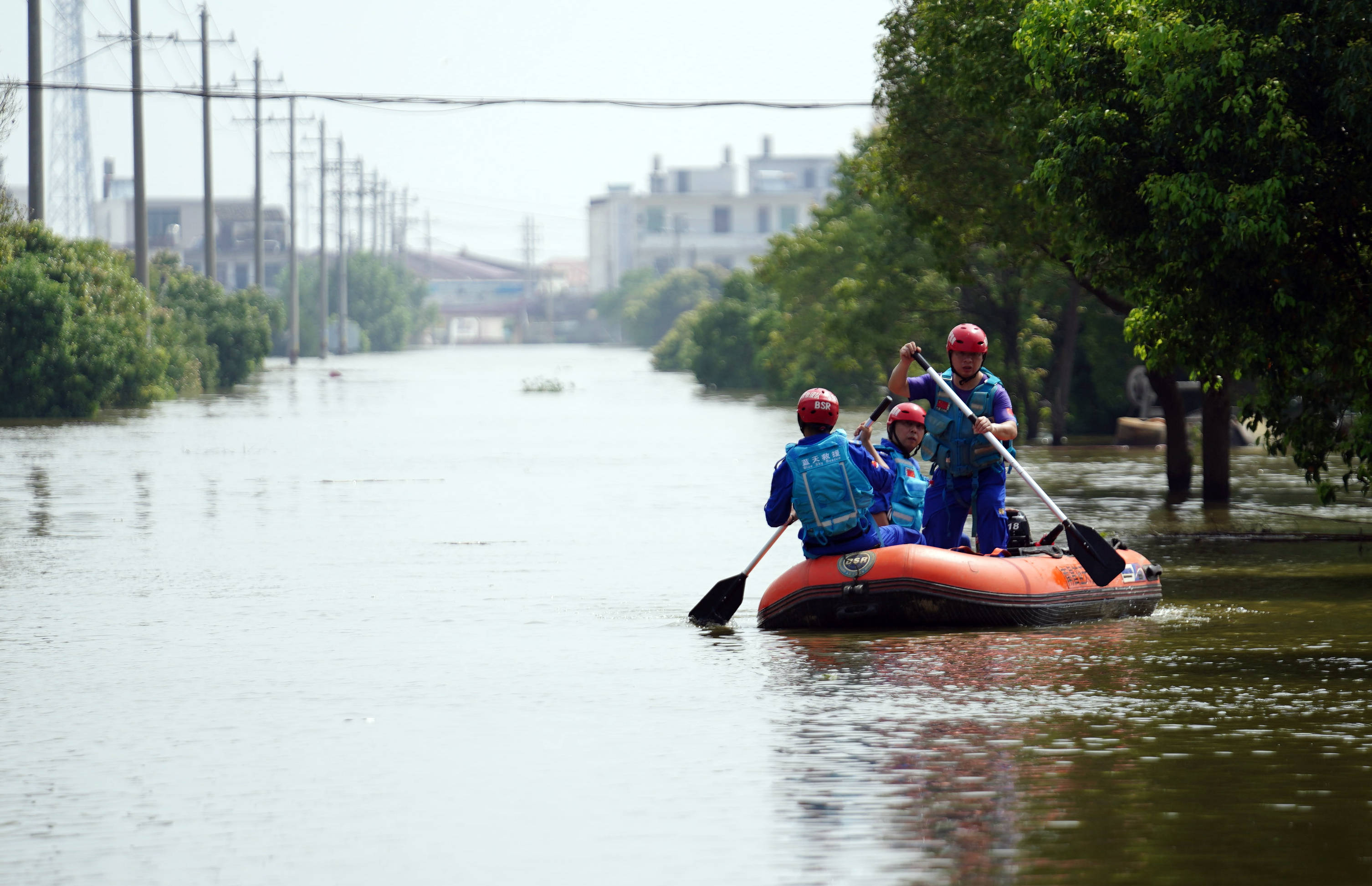 7月13日,在永修县三角乡,救援人员乘坐橡皮艇前往救援