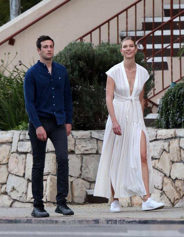 卡莉·克劳斯(karlie kloss)穿着时尚的白色长裙和丈夫在洛杉矶