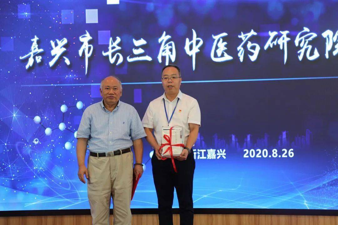 图为连建伟教授向长三角中医药研究院院长罗开涛授书接着,嘉兴市中医