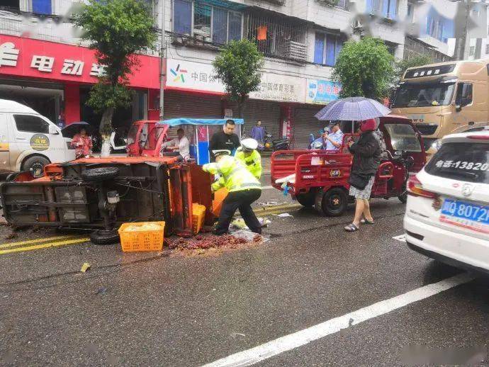 高縣一拉水果三輪車被追尾側翻,交警民警雨中撿水果.