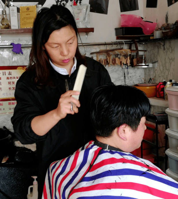 记者来到祝塘镇的阿军理发店时,徐彩琴正细致,熟练地为顾客理发