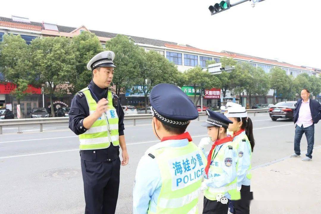 执勤过程中,小交警们还协助交警叔叔一起劝导骑电动车的人员佩戴头盔.
