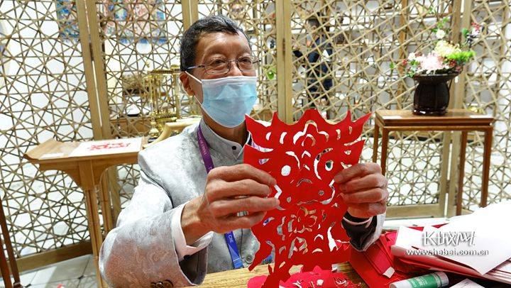 华兴富正在展示他的"撕纸"作品.长城网记者 胡晓梅 摄