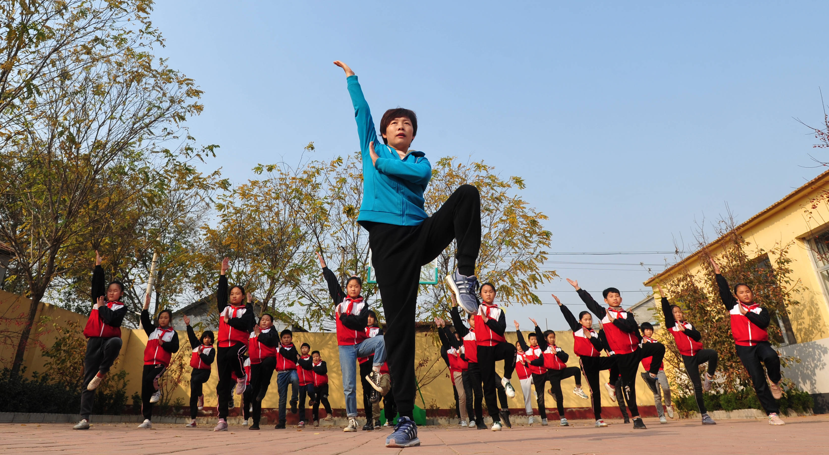 市沧县张官屯乡邱庄子小学体育教师于国风(前)为学生们演示武术动作