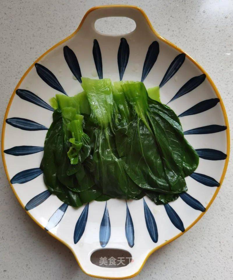 12. 将焯水的青菜铺在盘子里.