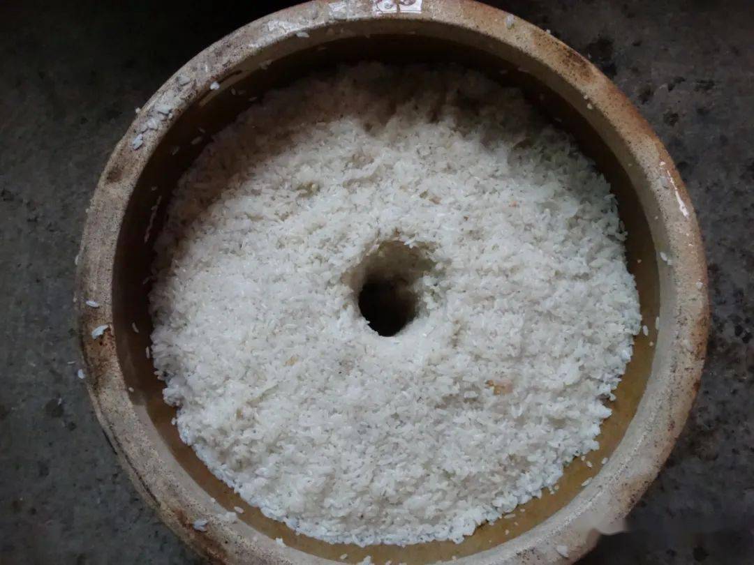 五,榨酒:将发酵充分的酒醪倒入纱布袋里,手工压榨过滤,获取乳白色的