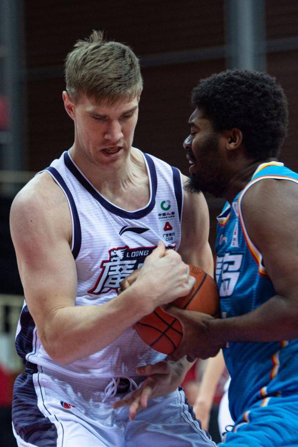 青岛每日优鲜队球员约翰逊(右)与时代中国广州队球员哈斯拼抢.