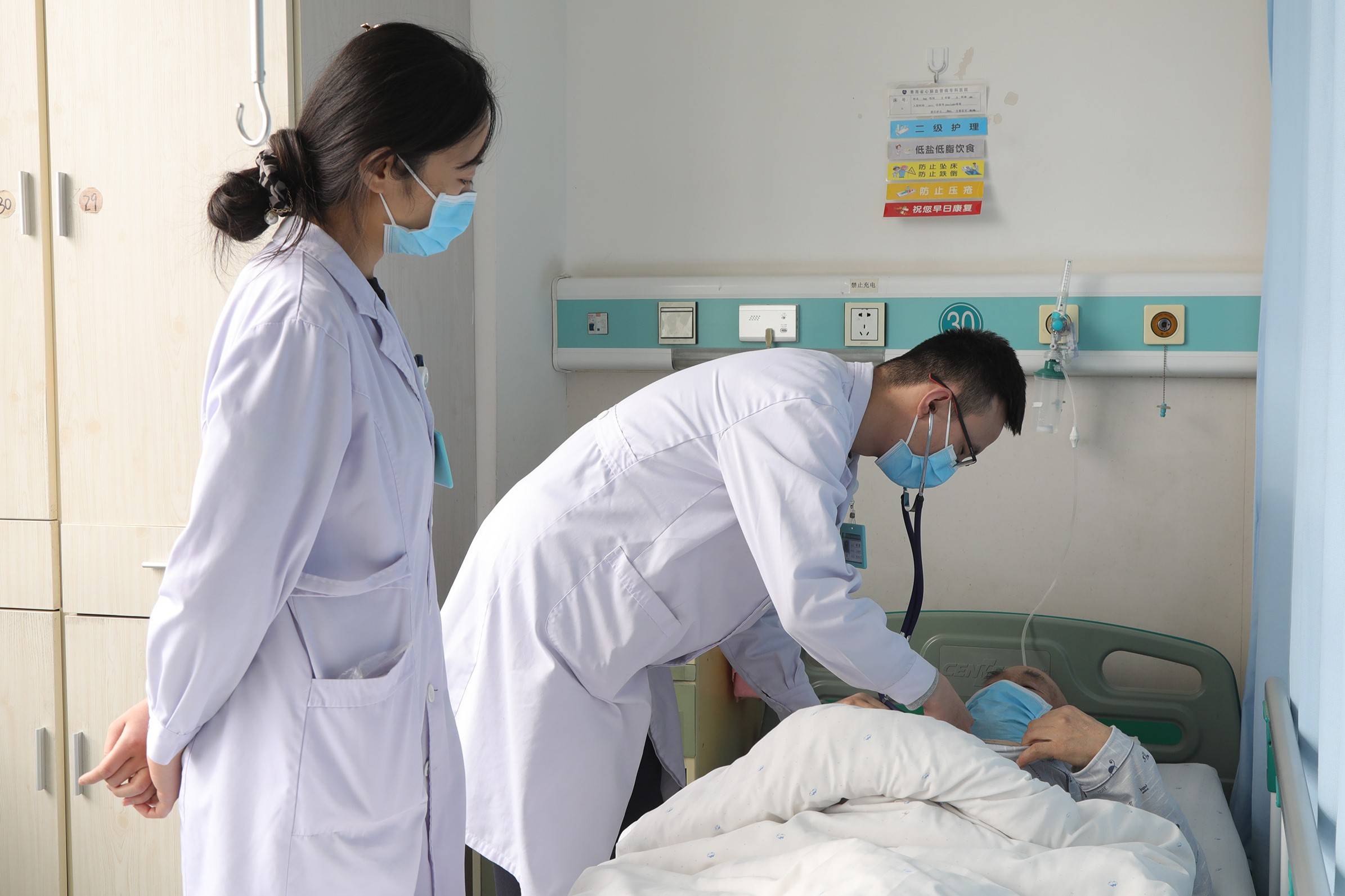 冠心病一科主治医师郗汇聪(左二)在为冠脉支架植入术术后患者听诊