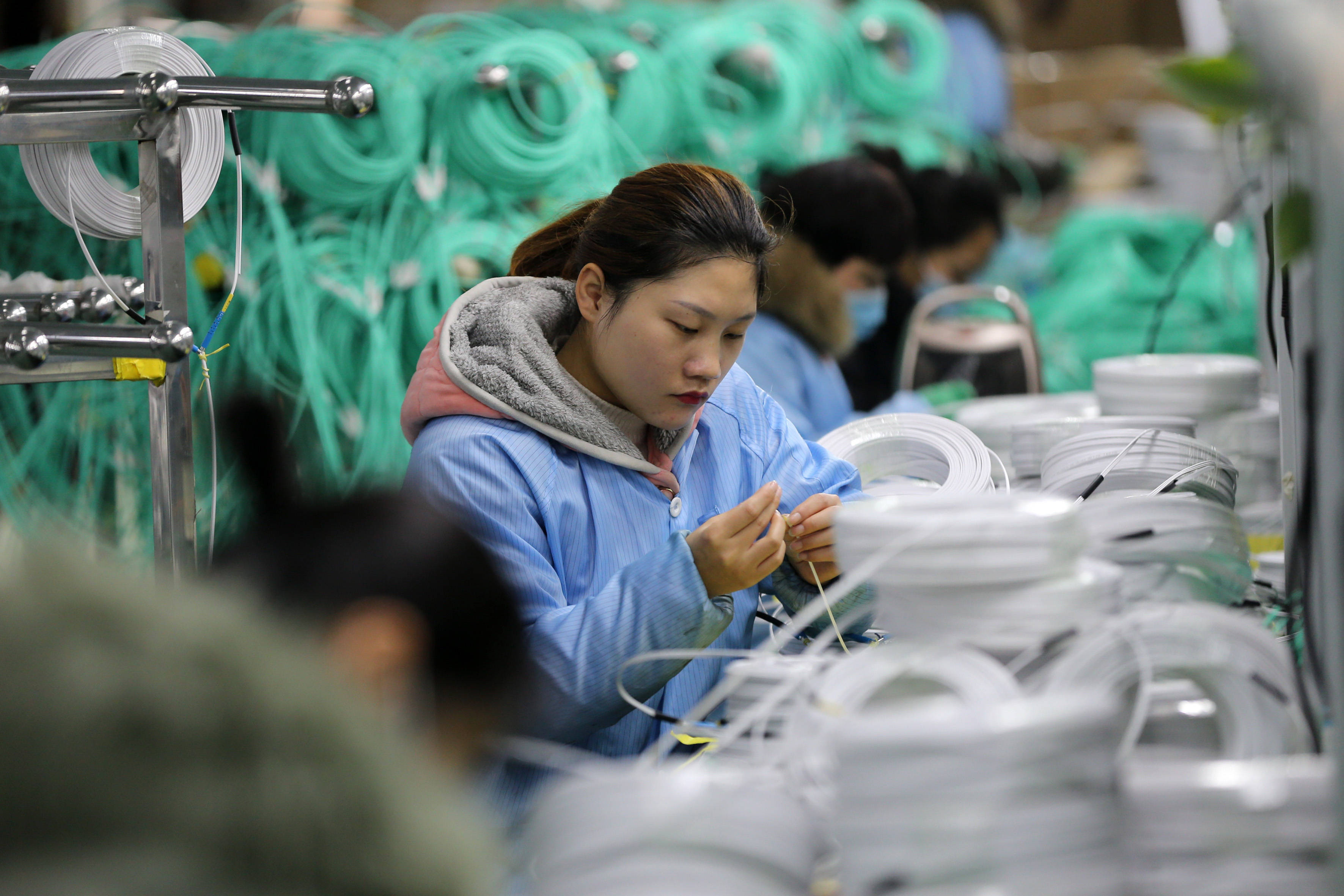 1月27日,在淮北市濉溪县经济开发区,工人在一家通信光缆生产企业车间