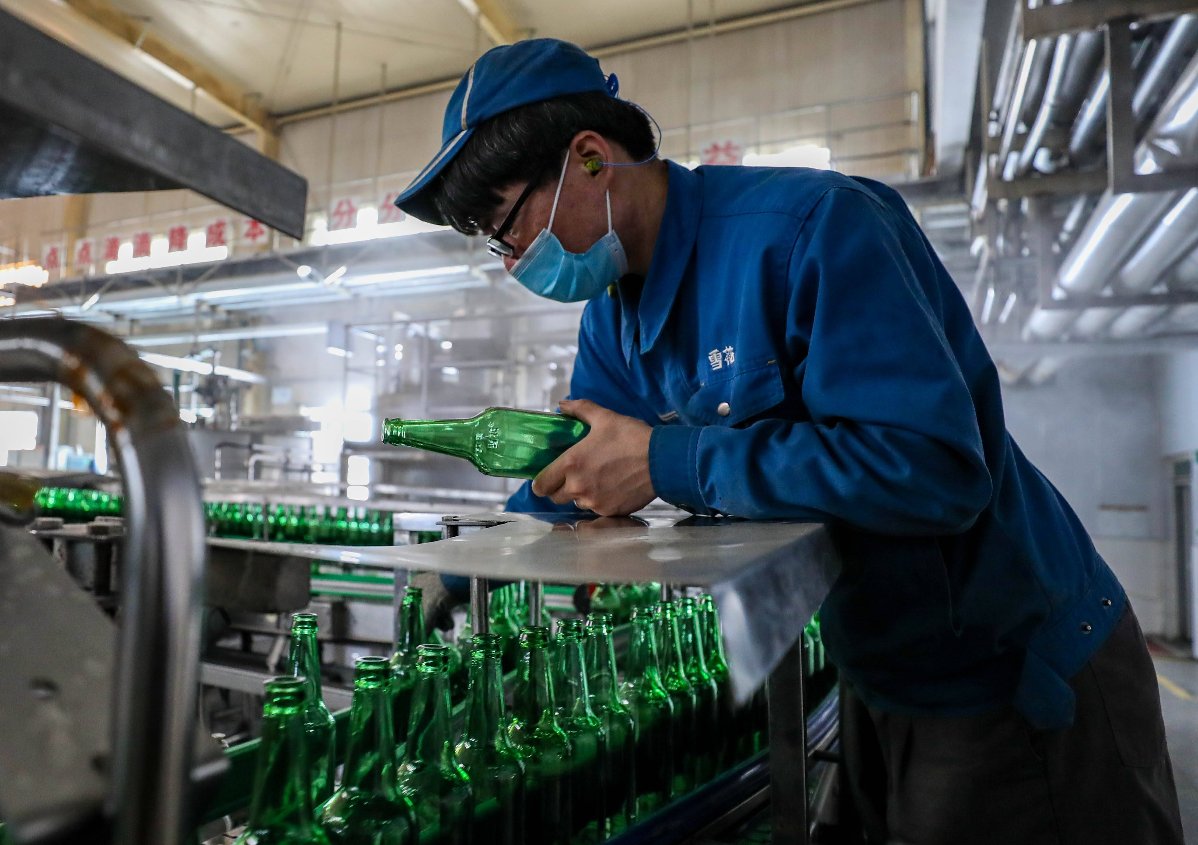2月21日,华润雪花啤酒(兴安)有限公司的工人在洗瓶机上作业.