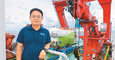 海试期间,赵洋在万米级载人潜水器"奋斗者"号前留影.