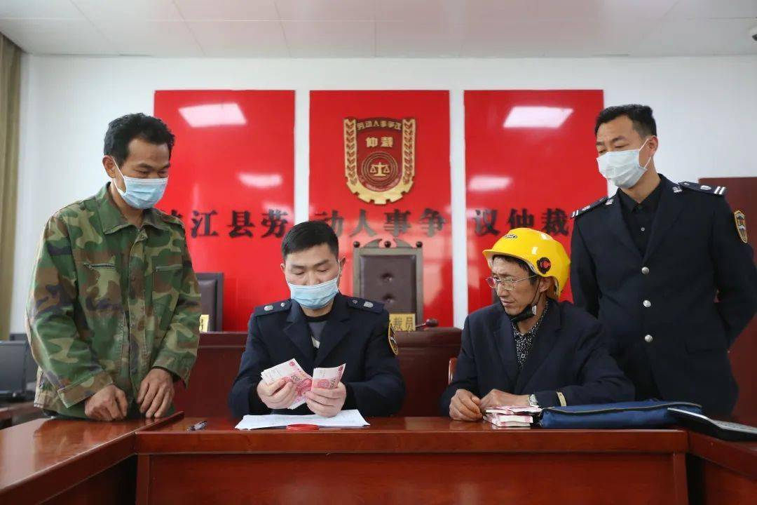 峡江县人社局劳动保障监察大队工作人员正在清点工资款项农民工高兴的