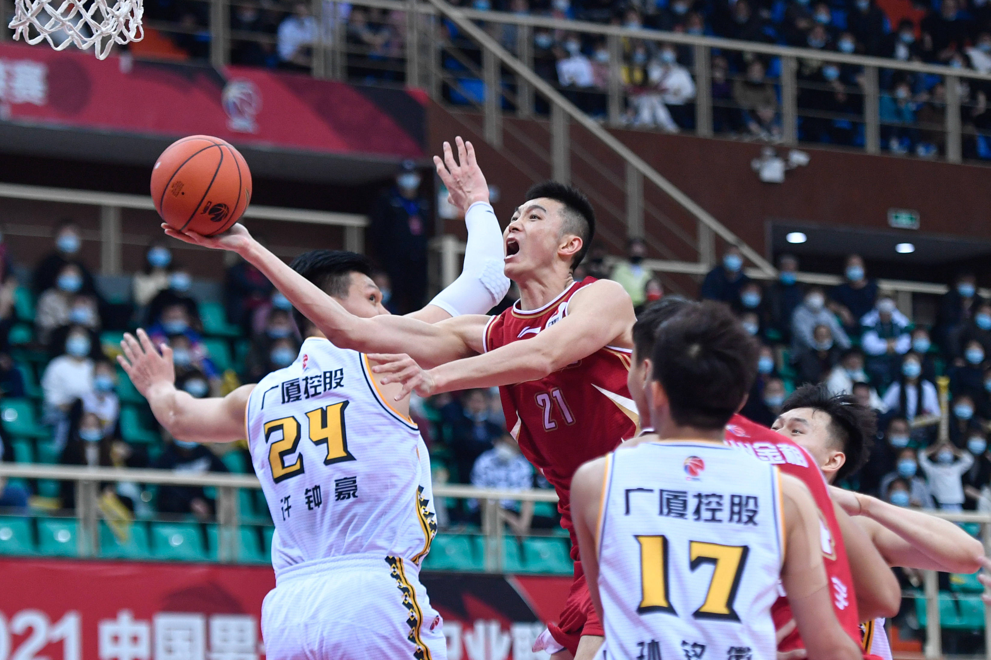 3月25日,浙江稠州金租队球员朱旭航(中)在比赛中上篮.